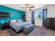 Comfortable main bedroom with a queen-sized bed, accent wall, ceiling fan, and a window letting in natural light at 858 W Knowles Cir, Mesa, AZ 85210
