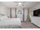 Bright bedroom with plush bedding, white furniture, a ceiling fan, and soft, neutral accents at 8788 W Wood Dr, Peoria, AZ 85381