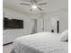 This bedroom features a white comforter, ceiling fan, and white dresser with doors to bathroom and closet at 8788 W Wood Dr, Peoria, AZ 85381