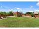 Expansive backyard featuring lush lawn, mature trees, and a detached structure, creating a serene outdoor space at 9435 E Hobart Cir, Mesa, AZ 85207
