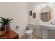 Powder room with pedestal sink, round mirror, tiled floor, and decorative wall art at 9435 E Hobart Cir, Mesa, AZ 85207