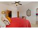 Bedroom features a red quilt, ceiling fan, carpet, and an ornate decorative mirror at 9435 E Hobart Cir, Mesa, AZ 85207