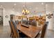 A dining room boasts an eye-catching chandelier and a grand wooden table perfect for meals and entertainment at 9435 E Hobart Cir, Mesa, AZ 85207