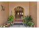 Inviting entryway featuring an arched doorway, neutral walls, potted plants, and a decorative lizard accent at 9435 E Hobart Cir, Mesa, AZ 85207