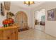 Warm foyer featuring unique decor, a decorative cabinet, tiled flooring, and an arched doorway at 9435 E Hobart Cir, Mesa, AZ 85207