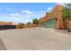 View of a spacious driveway leading to a three-car garage, complemented by well-maintained landscaping and desert charm at 9435 E Hobart Cir, Mesa, AZ 85207
