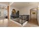 Bright hallway featuring decorative iron railing, neutral walls, tile floors, and elegant light fixtures at 9435 E Hobart Cir, Mesa, AZ 85207