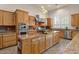 The modern kitchen is complete with stainless steel appliances, natural wood cabinets, and granite countertops at 9435 E Hobart Cir, Mesa, AZ 85207
