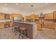 An open kitchen featuring an island with counter seating and wooden cabinetry with granite countertops at 9435 E Hobart Cir, Mesa, AZ 85207