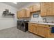Bright laundry room boasts wood cabinets, sink, countertop, and modern appliances at 9435 E Hobart Cir, Mesa, AZ 85207