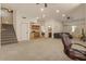 Open living space with carpet, stairs, adjacent kitchen and adjacent living area at 9435 E Hobart Cir, Mesa, AZ 85207