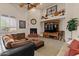 A cozy living room is adorned with a fireplace, TV, comfortable furnishings, and natural light at 9435 E Hobart Cir, Mesa, AZ 85207
