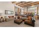 Spacious living room with beamed ceilings, comfortable seating, and seamless flow to the dining area at 9435 E Hobart Cir, Mesa, AZ 85207