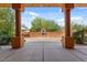 Covered patio offers a view of the landscaped backyard and outdoor fireplace at 9435 E Hobart Cir, Mesa, AZ 85207