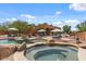 Inviting backyard pool and spa area with lounge chairs, umbrellas, and desert landscaping perfect for outdoor relaxation and entertaining at 9435 E Hobart Cir, Mesa, AZ 85207