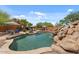 Resort-style backyard featuring a stunning pool with a waterfall, surrounded by lush landscaping and seating at 9435 E Hobart Cir, Mesa, AZ 85207