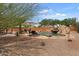 Lush backyard with beautiful landscaping and a stunning pool with a rock waterfall feature for a relaxing escape at 9435 E Hobart Cir, Mesa, AZ 85207