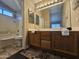 Bathroom featuring double sink vanity with wooden cabinets, large mirror, and a shower-tub combination at 9983 W Monterosa Ave, Phoenix, AZ 85037