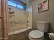 Bathroom featuring a tub-shower combination, window, decorative picture and toilet at 9983 W Monterosa Ave, Phoenix, AZ 85037