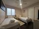 Cozy bedroom with two twin beds, ceiling fan, neutral walls and window with light-filtering blinds at 9983 W Monterosa Ave, Phoenix, AZ 85037