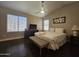 Bedroom featuring queen bed, wooden floors, ceiling fan, natural light, and neutral walls at 9983 W Monterosa Ave, Phoenix, AZ 85037