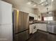 Modern kitchen features white cabinets, stainless steel refrigerator, and updated appliances at 9983 W Monterosa Ave, Phoenix, AZ 85037