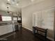 Well-lit kitchen area with white cabinets, stainless steel sink, and view into the living room at 9983 W Monterosa Ave, Phoenix, AZ 85037