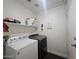 Laundry room equipped with modern appliances, shelf, and a closed white door at 9983 W Monterosa Ave, Phoenix, AZ 85037