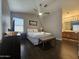 Bright main bedroom with a ceiling fan, ensuite bathroom, and wood-look flooring at 9983 W Monterosa Ave, Phoenix, AZ 85037