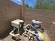 View of the pool pump and filtration system surrounded by a block wall and gravel at 9983 W Monterosa Ave, Phoenix, AZ 85037