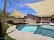 Pool area features artificial turf, shade sails, and built in barbeque at 9983 W Monterosa Ave, Phoenix, AZ 85037