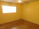 Bright bedroom with window and ceiling fan features yellow walls and concrete floors at 1019 E Granada Ave, Apache Junction, AZ 85119