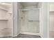 Bathroom featuring glass enclosed shower and open doorway to a walk-in closet with shelving at 11023 W Chino Dr, Peoria, AZ 85373