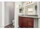 Bathroom featuring a granite countertop and vanity next to a toilet and an open doorway at 11023 W Chino Dr, Peoria, AZ 85373