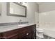 Bathroom with a dark wood cabinet, granite counters, and white tiled shower and tub at 11023 W Chino Dr, Peoria, AZ 85373