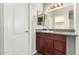 Bathroom featuring a granite countertop and vanity with a large mirror, next to a closed door at 11023 W Chino Dr, Peoria, AZ 85373