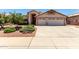 Charming single-story home featuring a spacious driveway, desert landscaping, and a two-car garage at 11023 W Chino Dr, Peoria, AZ 85373