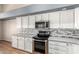 Close-up of updated kitchen featuring stainless steel appliances and modern tile backsplash at 11023 W Chino Dr, Peoria, AZ 85373