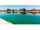 Scenic waterfront view capturing the reflections of lakeside homes in the calm, green waters at 11023 W Chino Dr, Peoria, AZ 85373