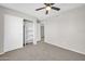 Spacious bedroom featuring a ceiling fan, carpet floors, and a closet for ample storage at 11044 N 75Th Dr, Peoria, AZ 85345