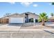 Charming single-story home featuring a two-car garage and a well-maintained, low-maintenance yard with a young palm tree at 11044 N 75Th Dr, Peoria, AZ 85345