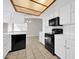 Well-lit kitchen with black appliances, white cabinets, and tile flooring at 11044 N 75Th Dr, Peoria, AZ 85345