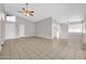 Spacious living room featuring neutral paint, tile floors, ceiling fan and plentiful natural light from clerestory windows at 11044 N 75Th Dr, Peoria, AZ 85345