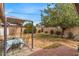 Outdoor dining space shaded by a pergola set amongst a beautiful landscaped lawn at 1179 E Cordova Ave, Casa Grande, AZ 85122