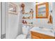 Bright bathroom featuring a toilet, vanity, mirror, and storage shelves at 1179 E Cordova Ave, Casa Grande, AZ 85122