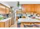 Well-lit kitchen with oak cabinets, white countertops, and stainless steel refrigerator at 1179 E Cordova Ave, Casa Grande, AZ 85122