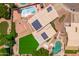 Bird's eye view of a home featuring solar panels, pool, grassy backyard, and adjacent putting green at 1203 W Escuda Rd, Phoenix, AZ 85027