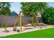 Backyard scene with a charming swing set and patio furniture nestled amidst green grass and lush greenery at 1203 W Escuda Rd, Phoenix, AZ 85027
