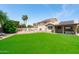 Expansive backyard featuring artificial turf, a covered patio, and solar panels on the home's roof at 1203 W Escuda Rd, Phoenix, AZ 85027