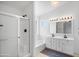 Bright ensuite bathroom with a glass shower, tub, window and a double vanity with nice lighting at 1203 W Escuda Rd, Phoenix, AZ 85027